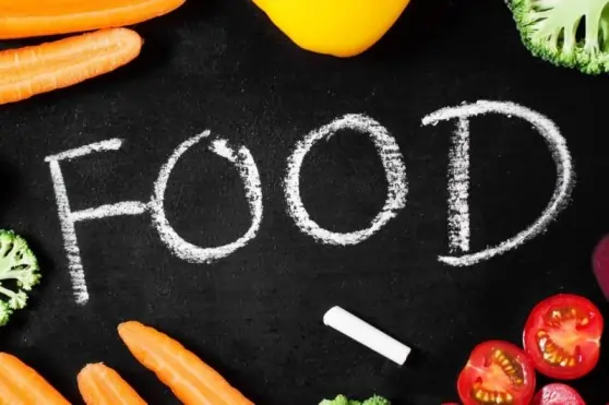 Vegetables surrounding the word FOOD in chalk, highlighting natural remedies for managing a chalk eating addiction.