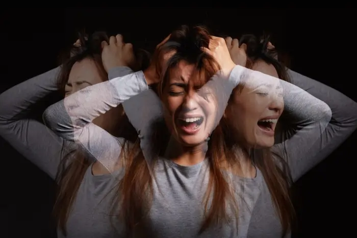 Woman experiencing intense paranoid anxiety with overlapping emotional expressions symbolizing fear, distrust, and mental distress.