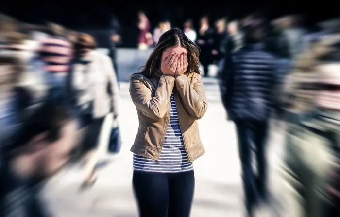 Person with hands on their face, overwhelmed by anxiety in a crowded place. Understand the causes, symptoms, and treatments of specific phobias, and learn how to overcome fears to improve your quality of life.