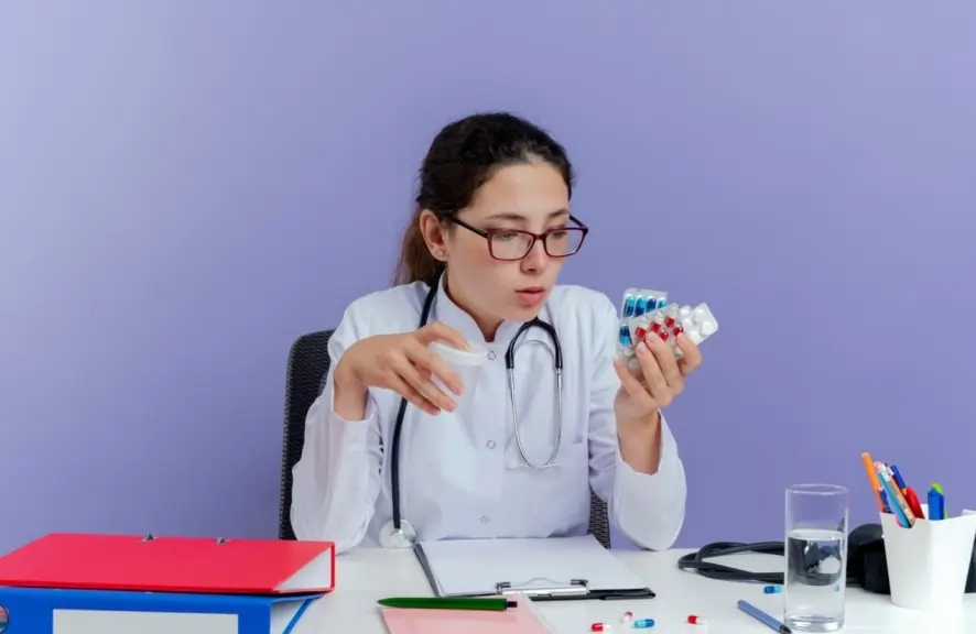 Doctor examining supplements to explain who is at risk for B12 deficiency while sitting at a medical desk.