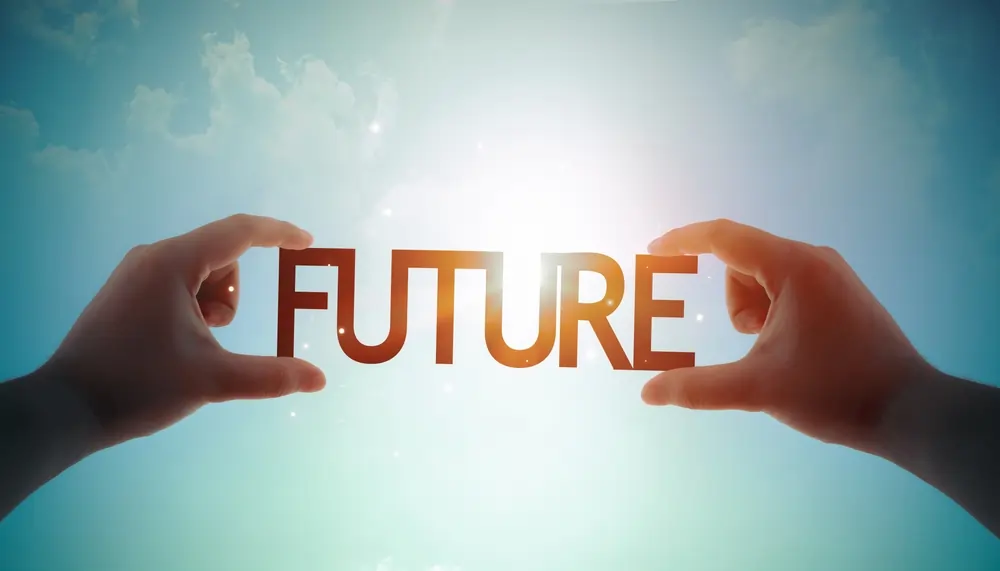 Two hands reaching out to grasp the word "FUTURE" against a bright, ethereal blue sky with sunburst lighting, symbolizing empowerment and a proactive approach to dealing with anxiety about the future.