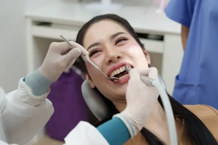 Dentist performing deep dental cleaning on a patient during a professional teeth cleaning procedure.