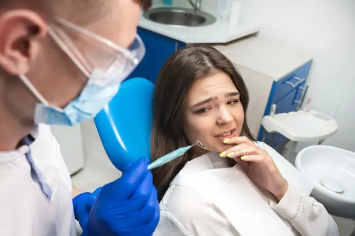 Dentist examining a woman suffering from severe tooth nerve pain to permanently stop tooth nerve pain.
